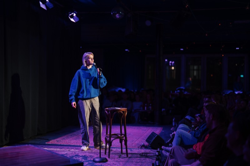 Comedienne auf der Bühne im violetten Licht